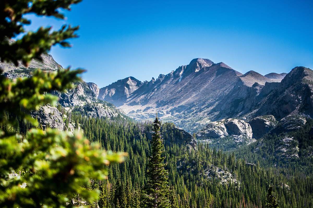 estes park green trees and snow coered mountains mountain range
